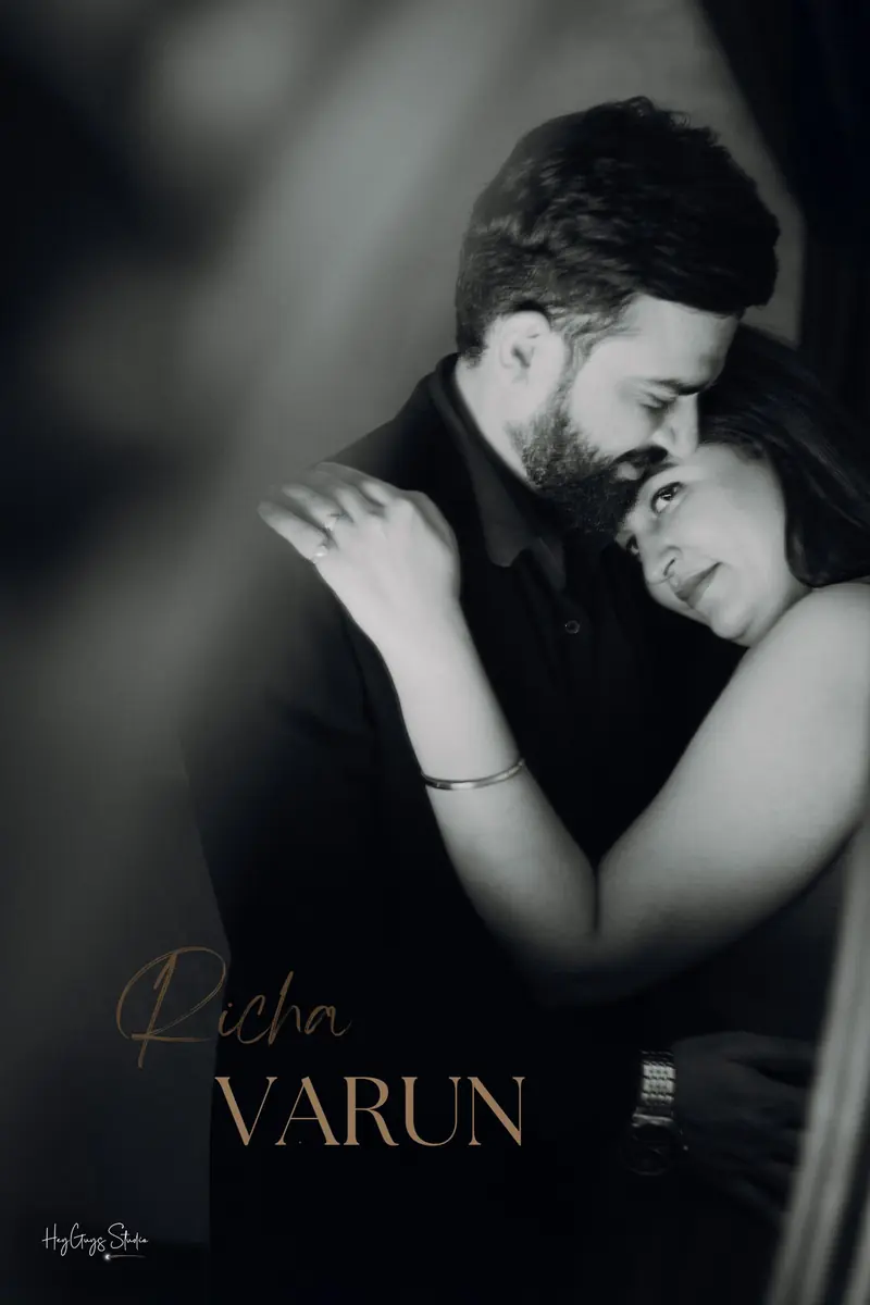 Black and white portrait of a couple leaning into one another during a pre-wedding session