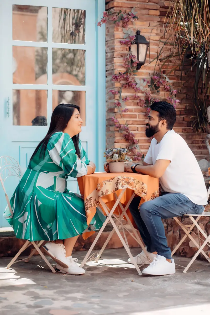 Couple sharing a quiet moment across a café table during a pre-wedding shoot at a heritage villa in Delhi NCR