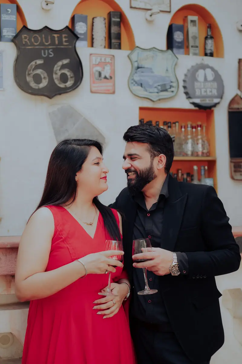 Couple raising a champagne toast inside a retro Americana-styled bar