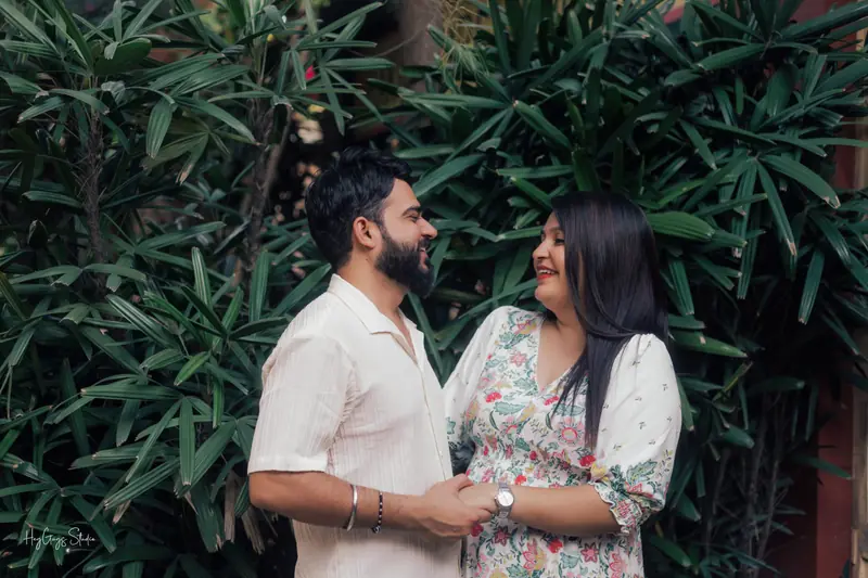 Couple laughing together framed by tall tropical foliage