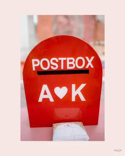 Album page featuring a decorated red postbox wedding prop with the couple's initials