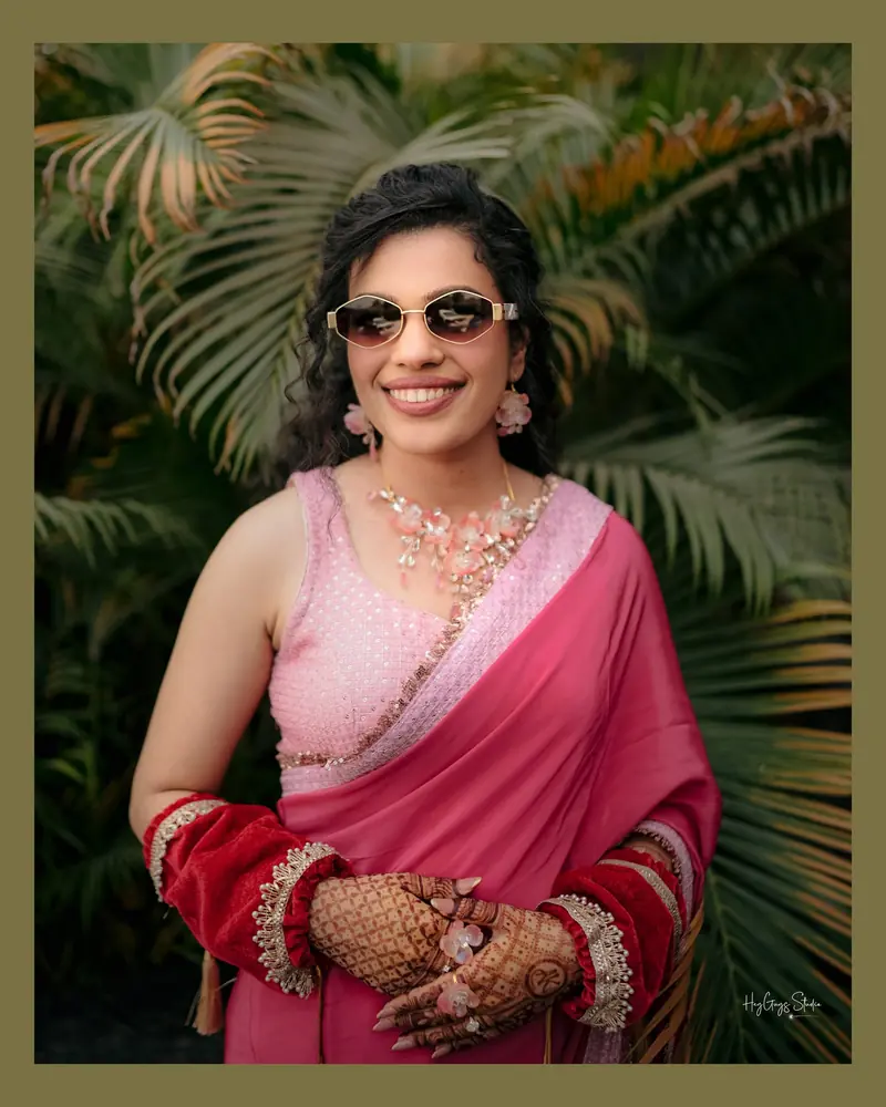 Radiant portrait of a bride in a pink saree with mehndi-covered hands on her Haldi day